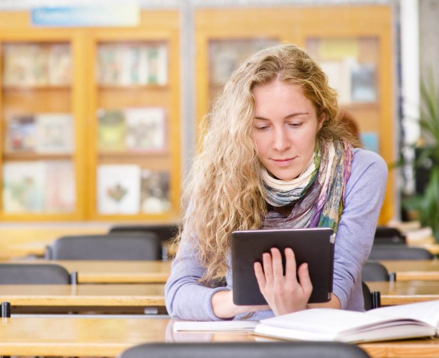female student with tablet computer in library